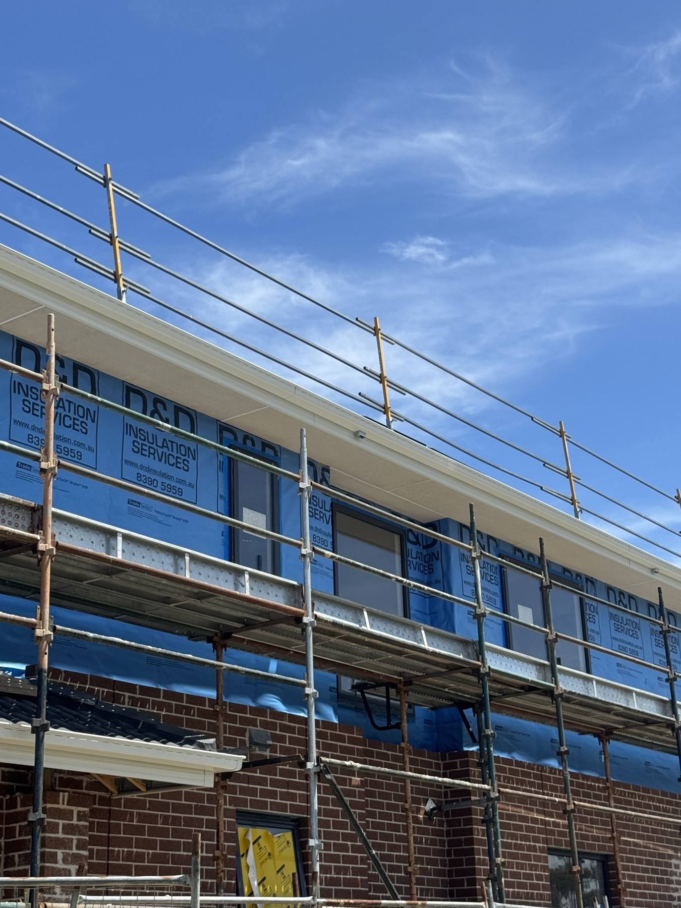 Two storey home with scaffolding during exterior carpentry work