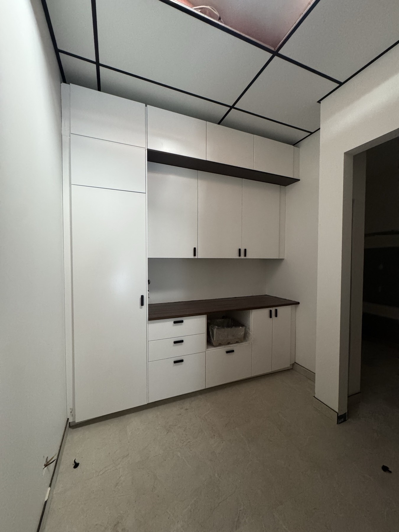 White fitted cabinetry with a dark benchtop